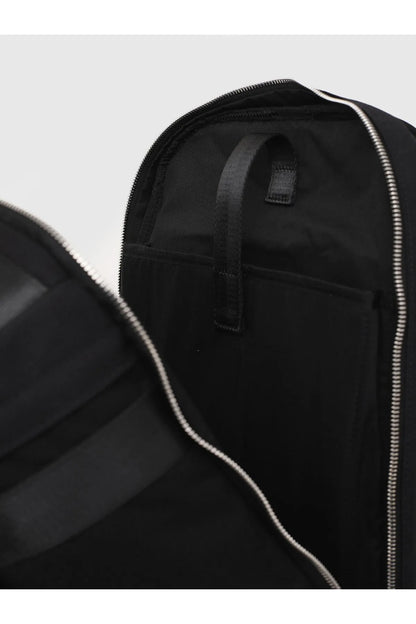 Black backpack interior pocket detail with zipper track and fabric tabs