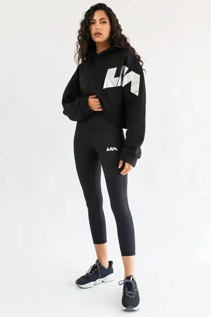 Black cropped leggings with white logo print and fitted mid-calf hem