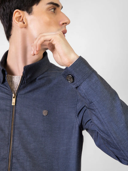 Men's dark blue zip jacket close-up: stand collar button and gold zipper