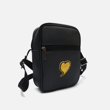 Black crossbody bag, front view, with zipper pocket and yellow heart patch
