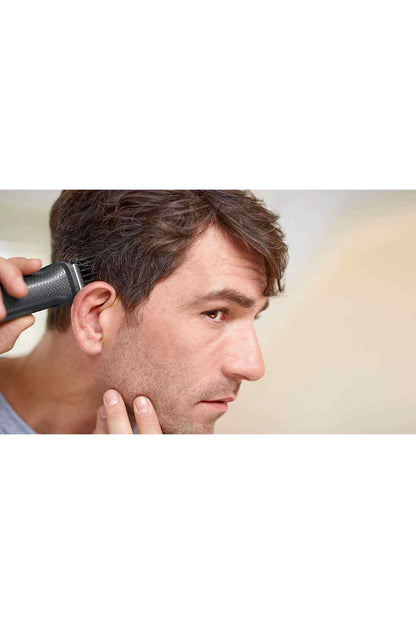 PHILIPS black trimmer being used on a man’s side hair