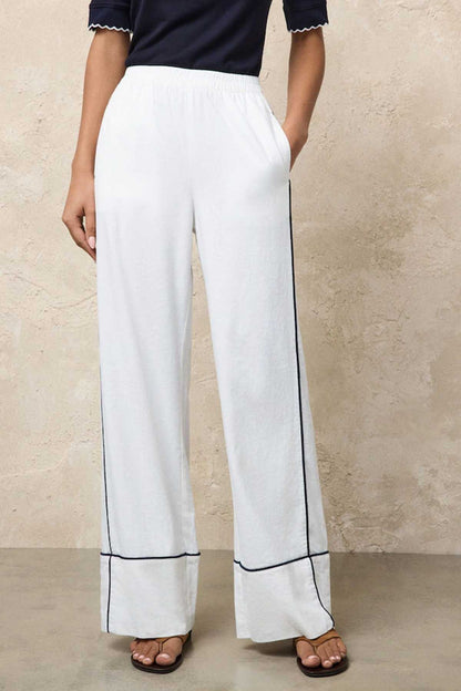 White wide-leg pants with navy piping along hems