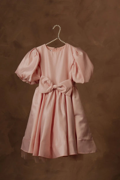 Pink puff-sleeve dress with waist bow and flared skirt, on pearl hanger.