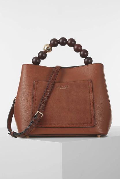 Brown leather handbag with beaded handle, front pocket flap, and gold hardware.
