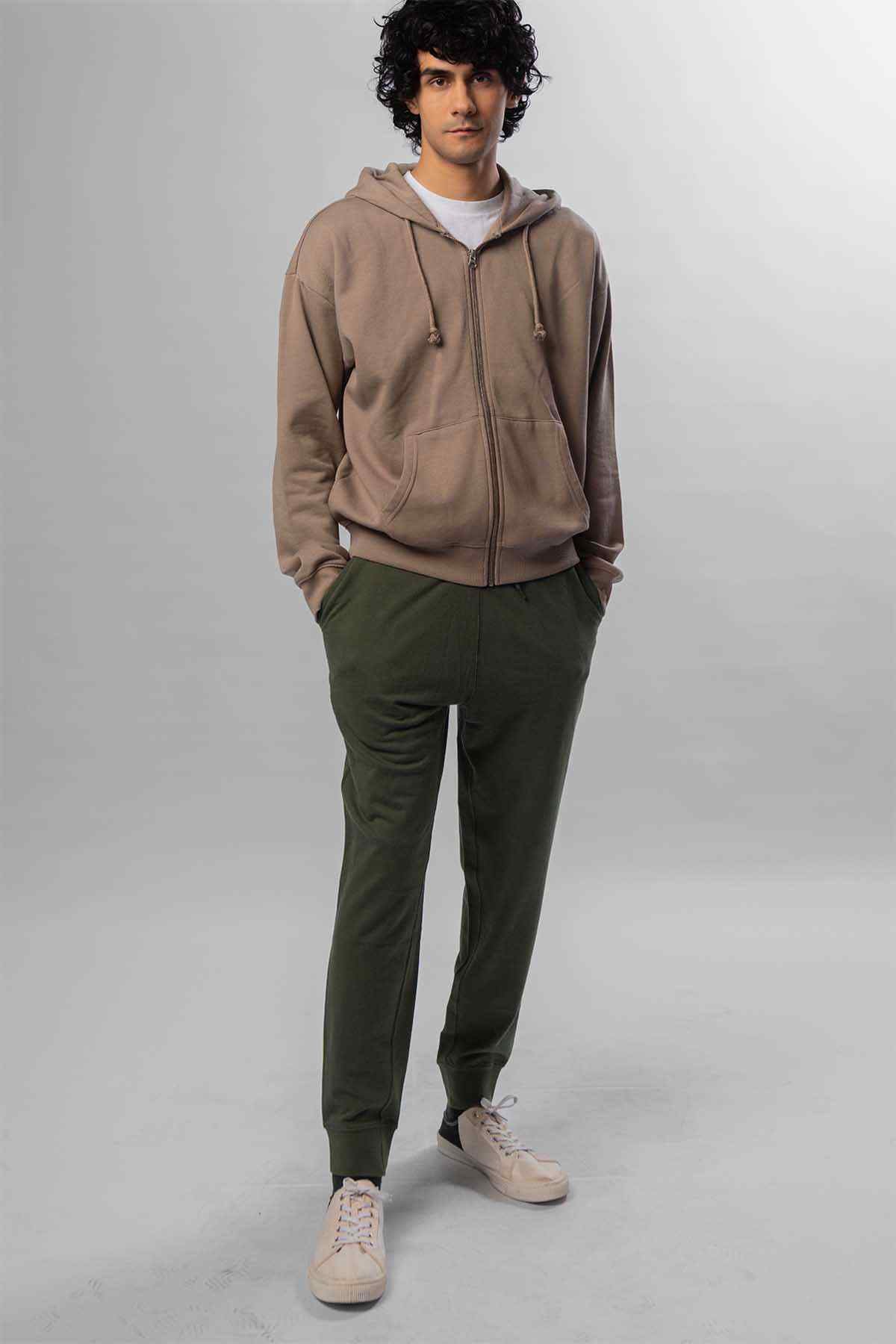 Levi's taupe zip hoodie with hood; green jogger pants, standing pose