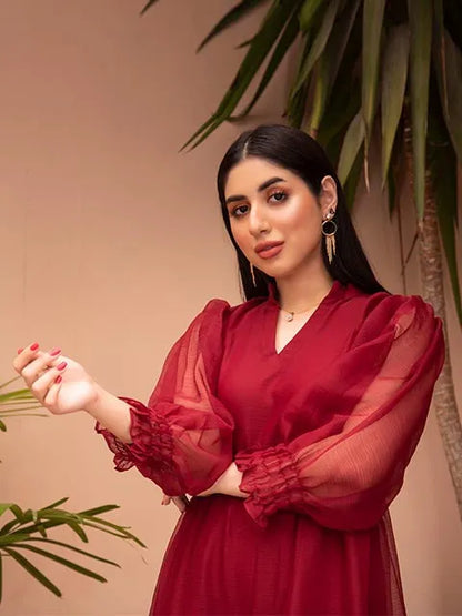 Deep red V-neck tiered midi dress with sheer sleeves and ruffle cuffs, close-up upper body.