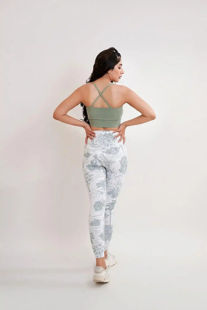 Back view of green sports bra with crisscross straps; botanical print leggings