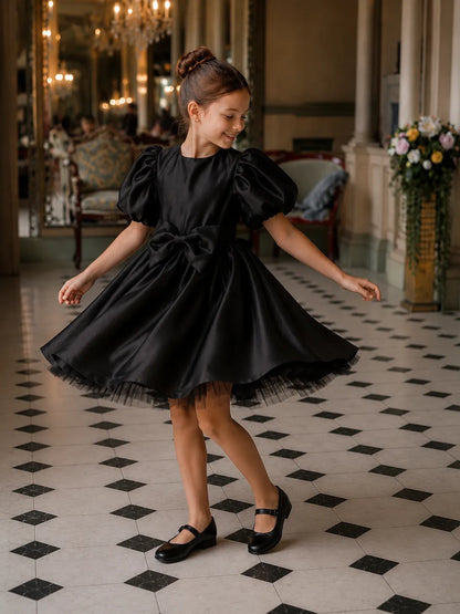 Black puff-sleeve satin dress with bow waist and flared tulle hem