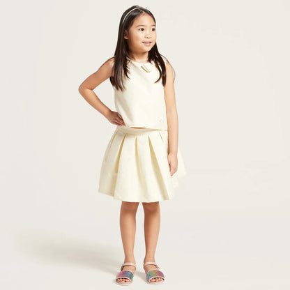 Sleeveless cream dress with light yellow pleated skirt and round neckline