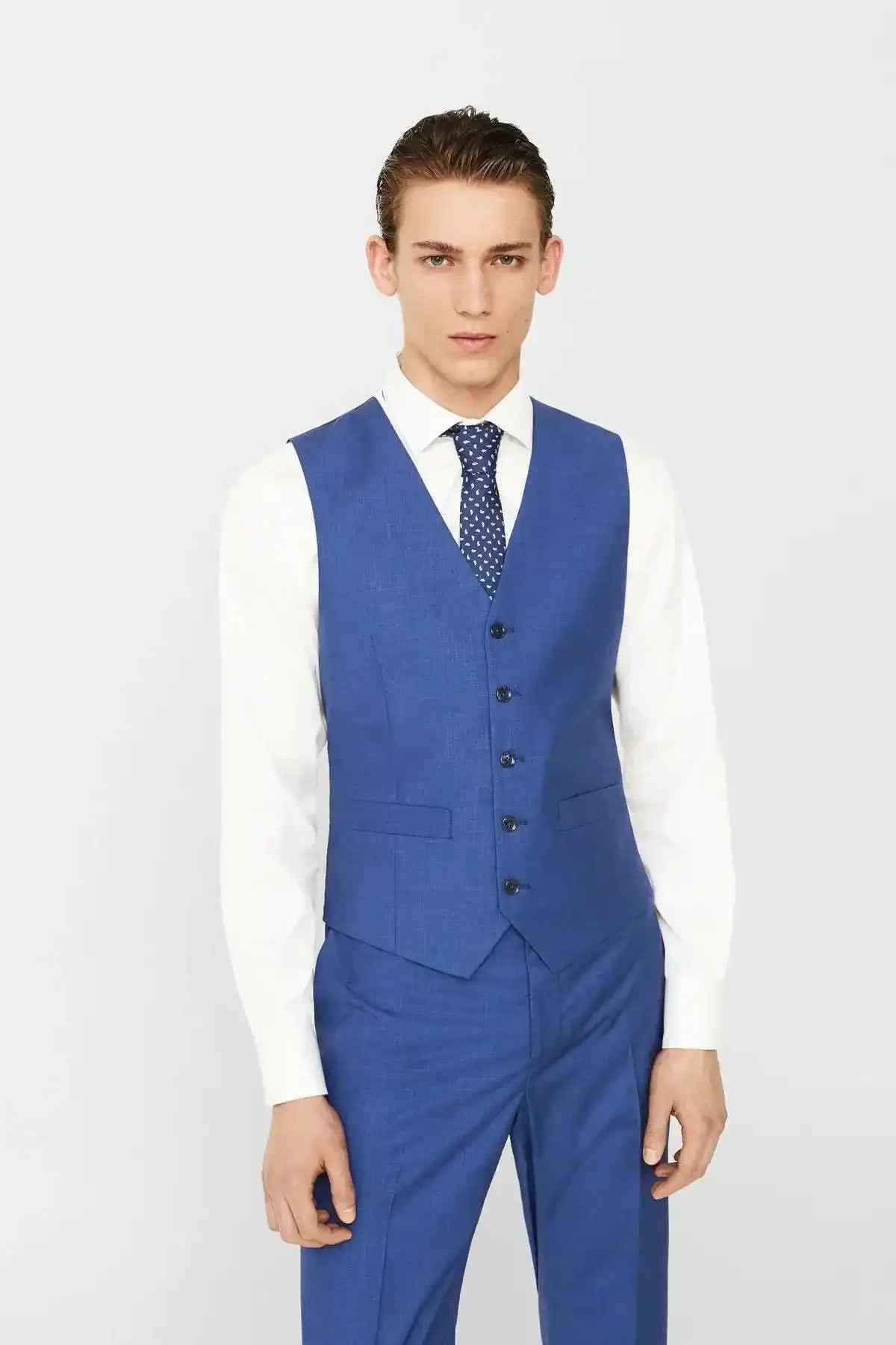 Men's blue suit vest with button front, worn over a white dress shirt