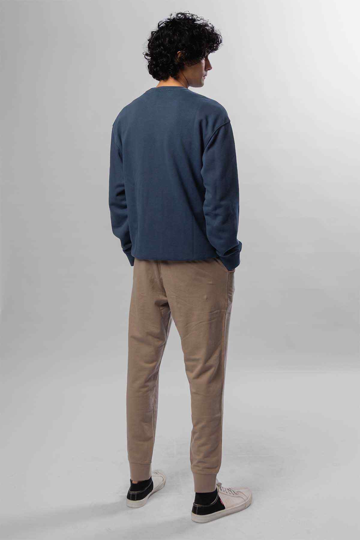 Levi's navy crewneck sweatshirt, back view; beige tapered pants