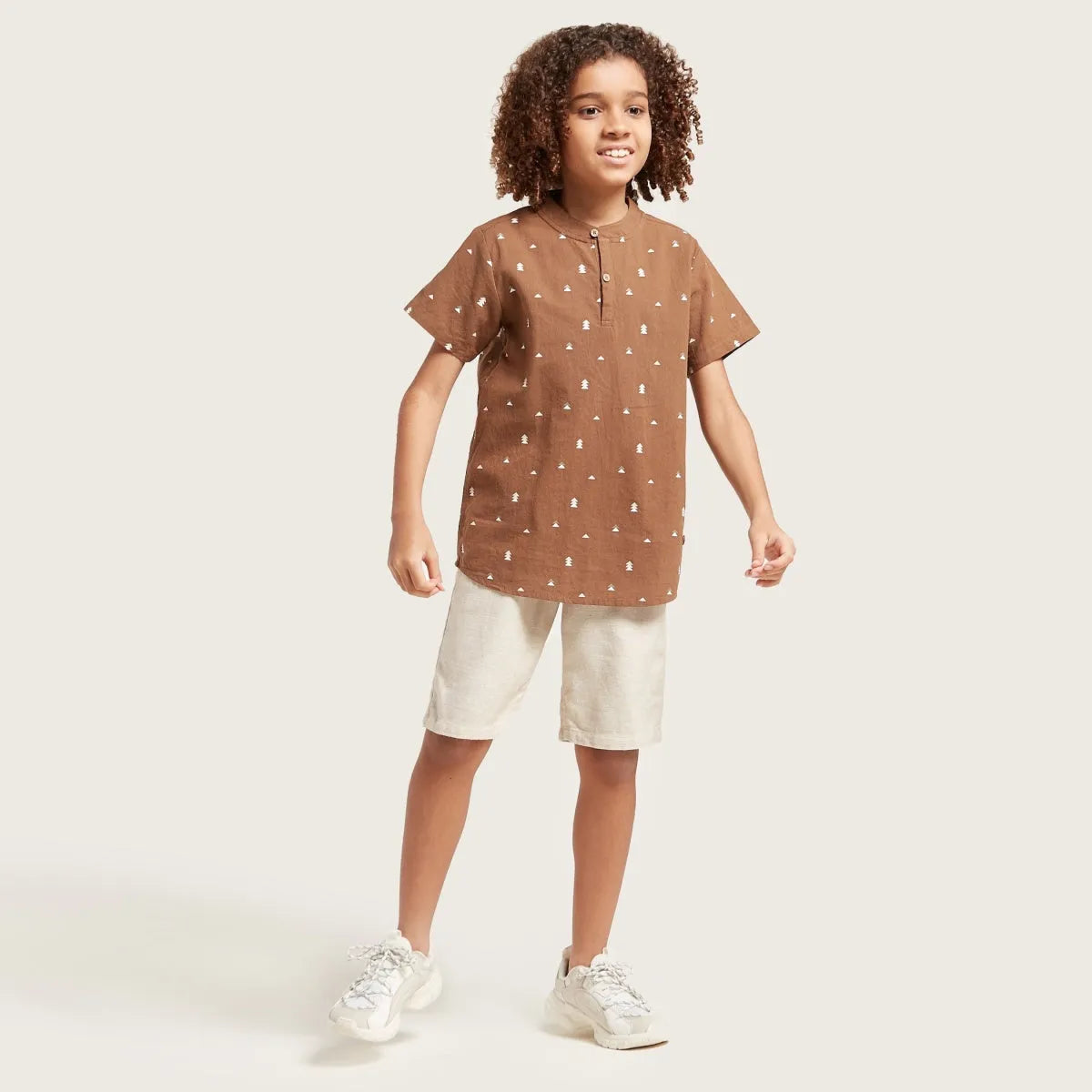 Brown short-sleeve kids shirt with button front and allover small-print pattern