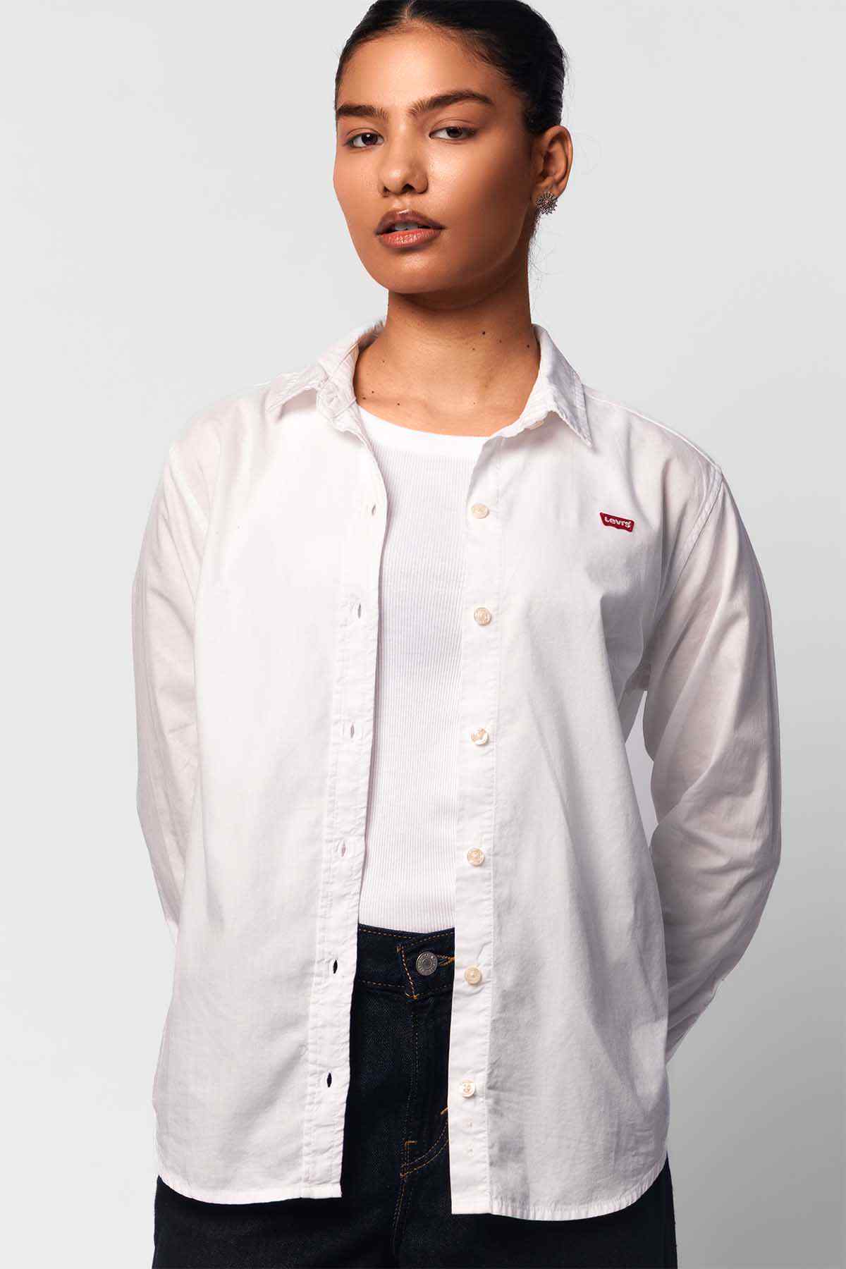 White button-up shirt with long sleeves, pointed collar, small chest logo