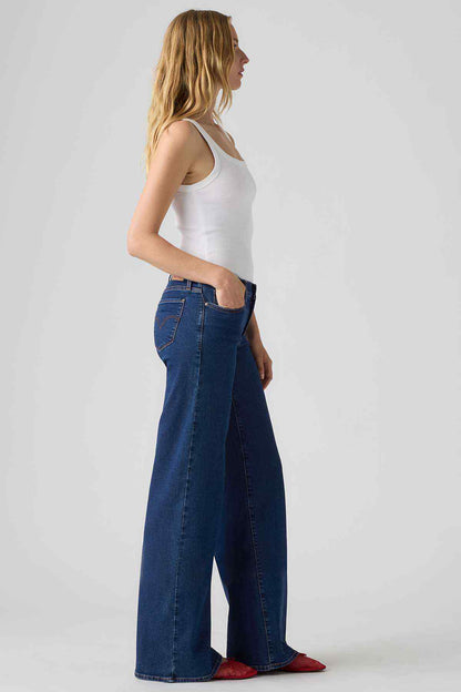 Women’s medium indigo wide-leg jeans, side view with deep front pockets and belt loops