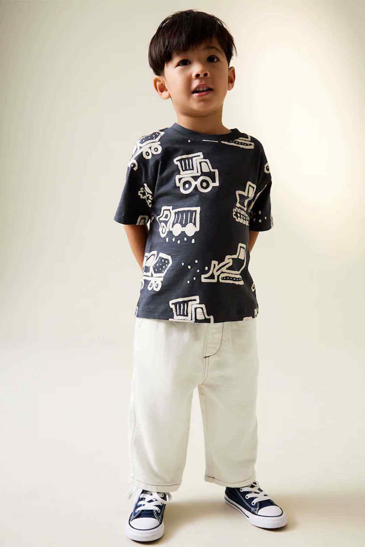 Kids black graphic T-shirt and ecru pants outfit, short sleeves and sneakers