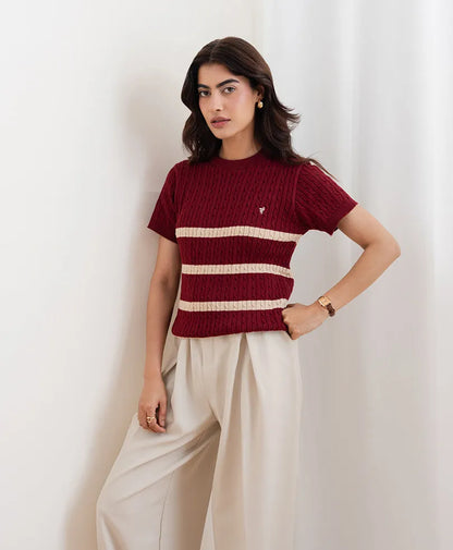 Red fitted knit top with crew neck, short sleeves, and cream stripe bands over a slim silhouette