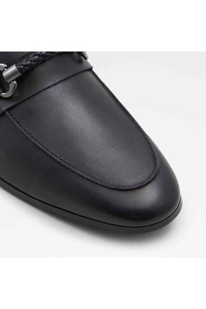 Black leather loafer toe close-up with stitched apron and metal hardware