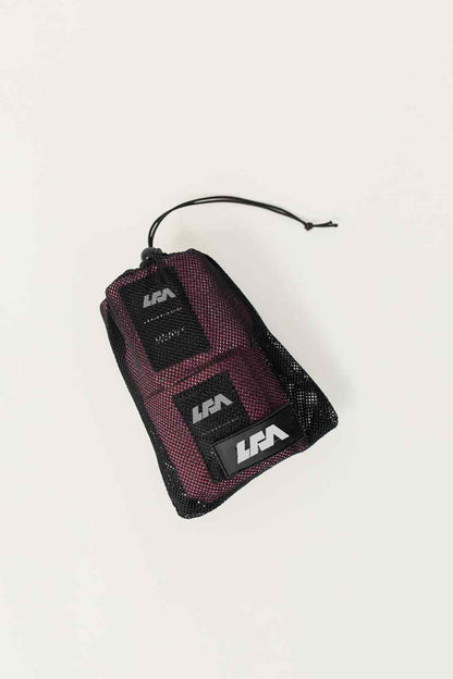 Pink and black resistance bands in mesh drawstring storage bag