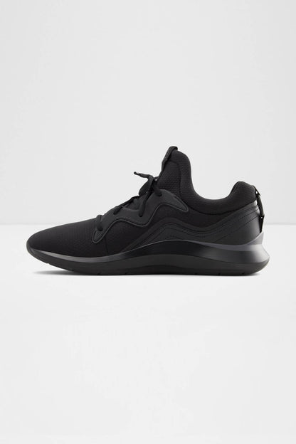 Black athletic sneakers, angled side view with lace-up closure and thick sole