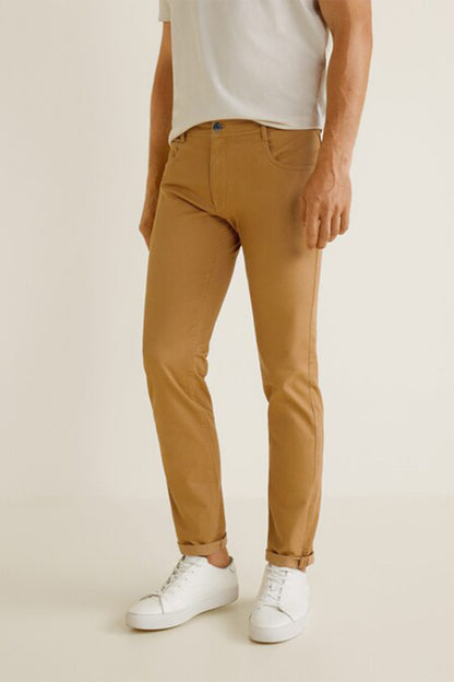 Tan chino pants with belt loops, zip fly, and tapered legs