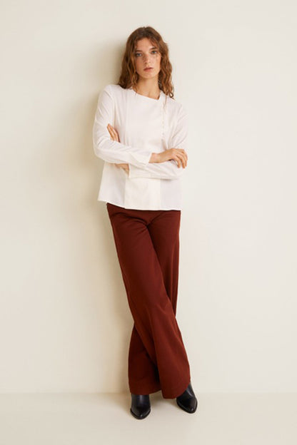 Off-white long-sleeve blouse with button front and wide-leg rust trousers, front view