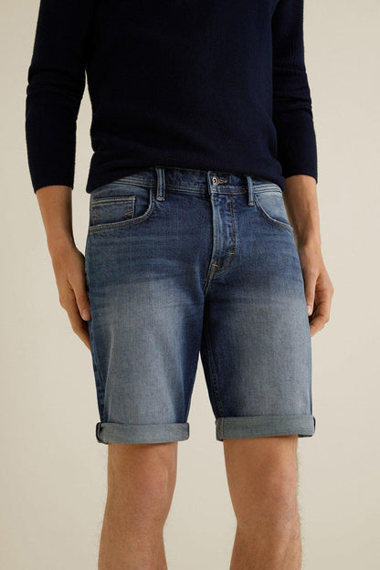 Dark blue denim shorts worn with cuffs and front button fly