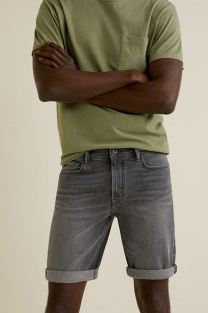 Denim grey knee-length shorts on a model, with front pockets and belt loops