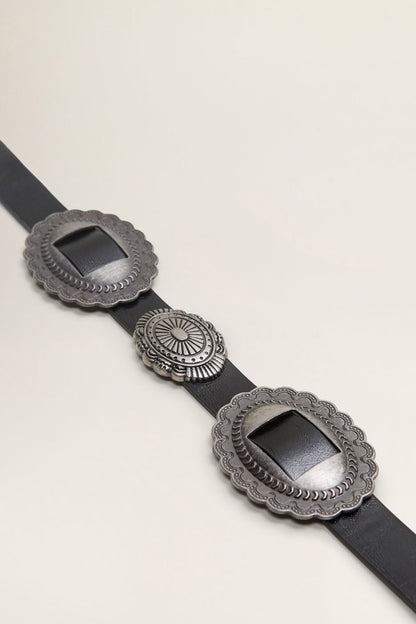Black belt detail: oval conchos and central round medallion on textured strap