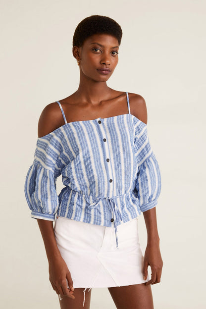 Blue-and-white striped off-shoulder blouse with button front, paired with white mini skirt