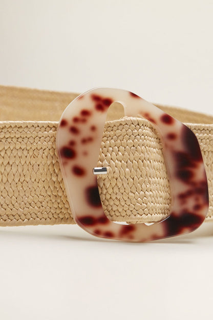 Sand woven belt close-up with tortoiseshell-look oval buckle and metal pin