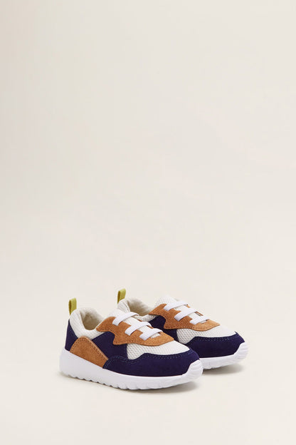 Navy and tan lace-up sneakers with orange-brown laces and white cushioned sole