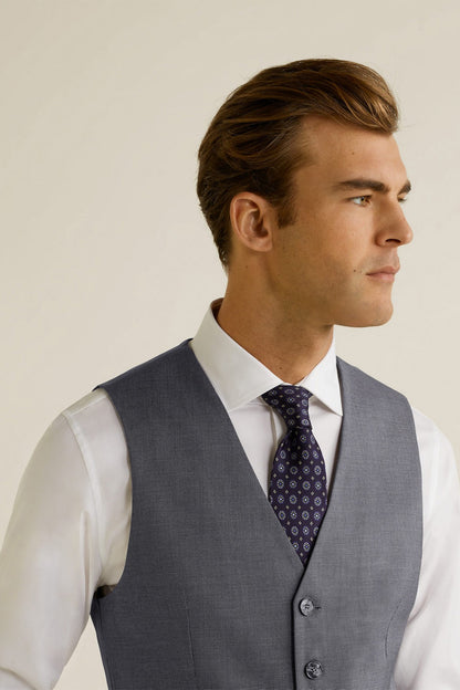 Grey suit vest with V-neck and button front, worn with patterned tie