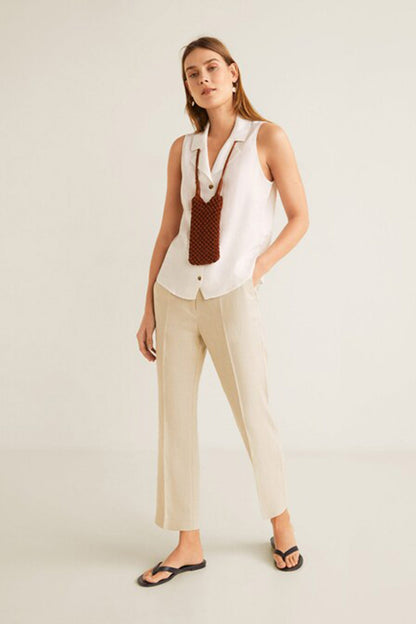 MANGO white sleeveless button-up shirt vest worn with light trousers and sandals