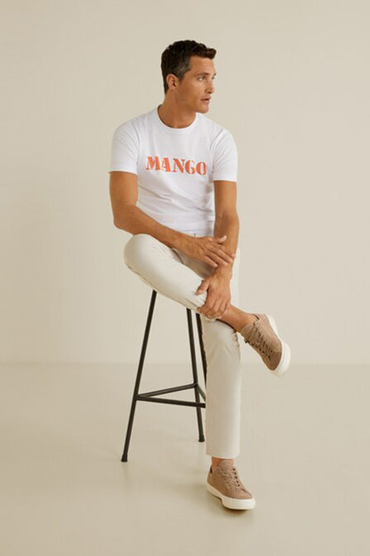Men's white T-shirt with orange MANGO logo, worn with light jeans