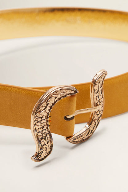 Mustard leather belt with curved silver-tone buckle close-up and prong