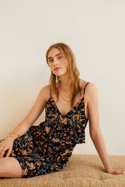 Black floral V-neck slip dress with spaghetti straps, worn with sandals