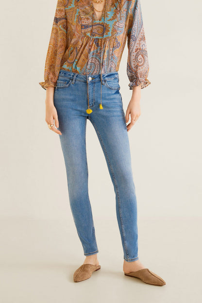 Women’s mid-blue denim skinny jeans with button closure, belt loops, and back pockets