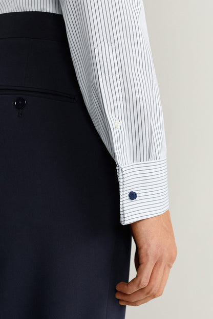 White pinstripe dress shirt cuff with buttoned sleeve and vertical stripes