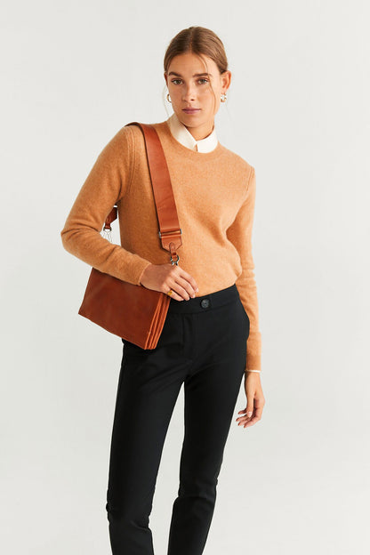Camel long-sleeve knit sweater with black slim trousers and crossbody strap