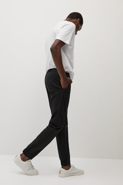 Black slim trousers with cuffed ankle, belt loops, side view