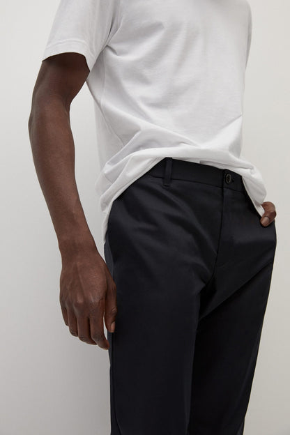 Black trousers close-up: button closure, belt loops, front crease