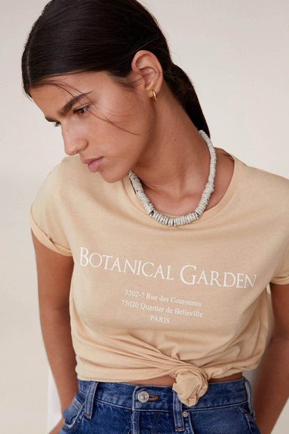 Beige T-shirt with BOTANICAL GARDEN text and front knot detail