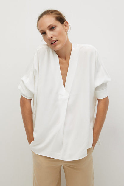Off-white blouse with V-neck and short sleeves, draped front