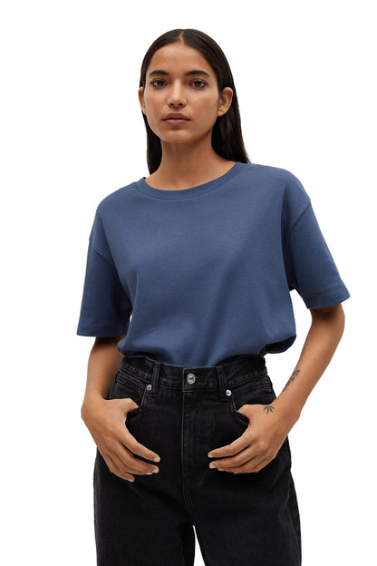Blue crew-neck short-sleeve T-shirt worn with black jeans