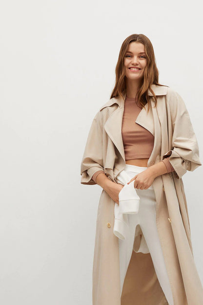 Camel ribbed knit crewneck crop top peeking under light beige jacket.