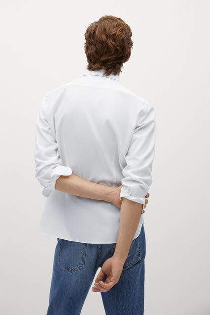 Back view of off-white button-up shirt with long sleeves and curved hem