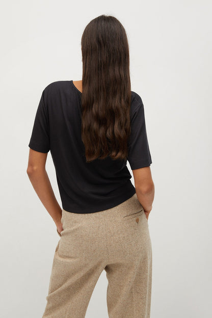 Black short-sleeve top and beige wide-leg trousers, back view