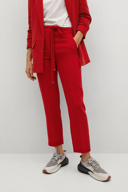 Red tailored trousers with tie waist, ankle length, worn with red blazer