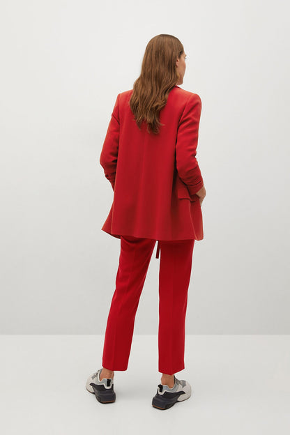 Red blazer and matching trousers set, seen from back with dark sneakers