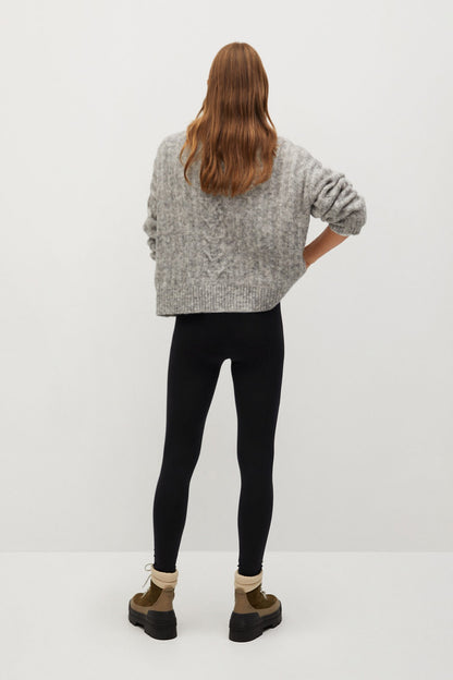 Gray knit quarter-zip sweater from back with black slim leggings